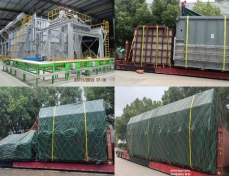 Inside a manufacturing plant: large gray industrial equipment with green framework and yellow safety rails.